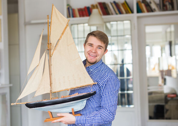 运输爱好 收藏 船和人的概念-帅哥举行帆船布局航海冒险帆船