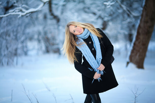 脸美丽的年轻女孩微笑着走在街上衣服雪自然