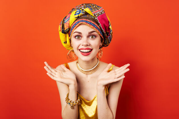 文化头上戴着五颜六色头巾的女人半个化妆品装饰隔离墙模特头项链