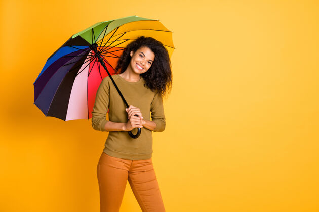 民族照片中波浪欢快的可爱休闲迷人迷人的牙齿微笑的女孩躲在雨伞下 在生动的色彩背景下孤立远离雨水时尚隐藏甜蜜