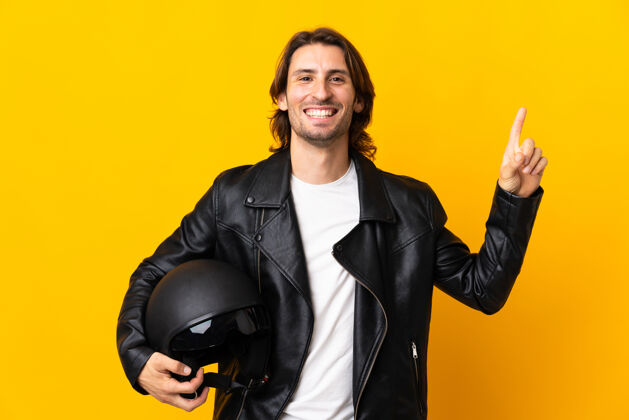 肖像一个戴着摩托车头盔的男人被隔离在黄色的墙上 他提出了一个好主意男性摩托车手显示