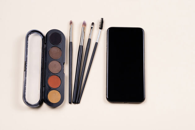 产品化妆在线课程学习调色板眼影 化妆品刷子和智能手机的空屏幕趋势影响者内容