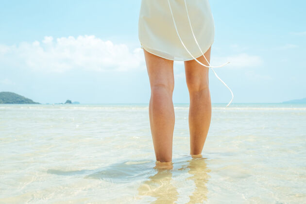 户外低角度的女人赤脚走在沙滩上宁静水平海滩