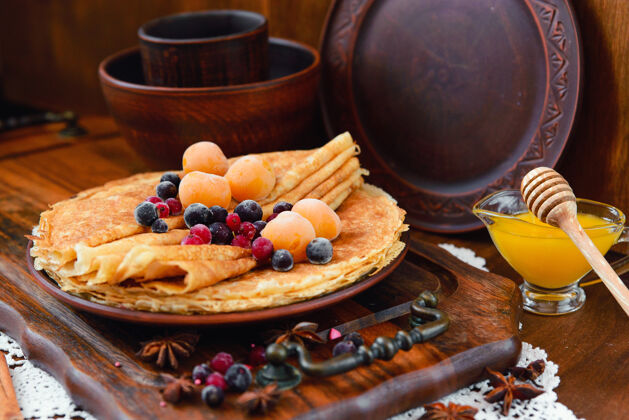 甜的金煎饼 冷冻水果 装饰和蜂蜜在一个乡村风格食物小吃吃