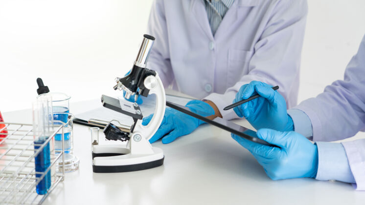 制药身着实验室工作服 戴着护目镜的年轻科学家团队 在实验室用试管进行分析试验或研究科学分析团队