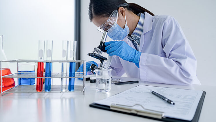 玻璃医学或科学研究人员或男医生在实验室里看着透明溶液的试管医学研究化学家