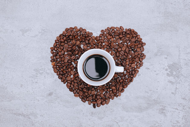 饮料俯瞰一杯咖啡上美丽的心形咖啡豆订婚美丽豆