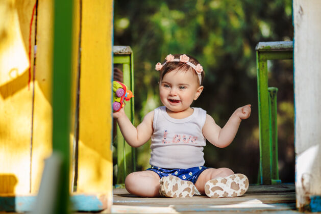 宝宝可爱的八个月大的婴儿在操场上笑着拿着她的玩具可爱有趣肖像