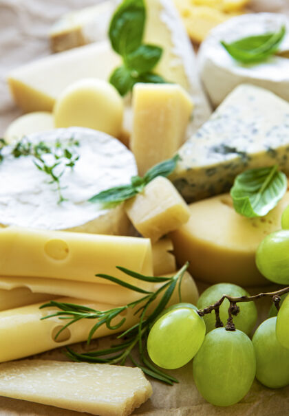 美食桌上摆着各种奶酪 罗勒和葡萄乳制品蓝奶酪不同