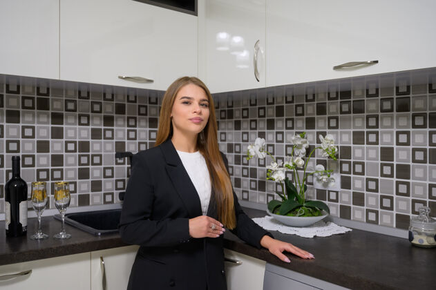 女士年轻的女设计师或业主在豪华现代黑白厨房室内设计干净内厨房烤箱