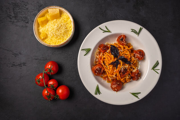 地中海意大利面配烤番茄 磨碎的帕尔马干酪和香蒜酱 放在深石墨背景的陶瓷碗中 俯视图 复制空间奶酪景观饮食