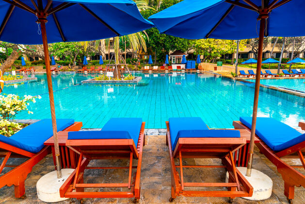 椅子酒店游泳池周围有漂亮的伞和椅子度假酒店假日音乐会度假村树天空