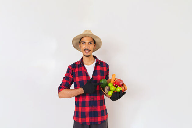 蔬菜一个戴着帽子和手套的黑人农民手里拿着一篮子蔬菜（胡萝卜 柠檬 西红柿 佛手瓜和甜菜） 背景是白色的携带男人柠檬