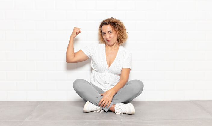 肌肉中年女性感觉快乐 满足和强大 屈曲适合和肌肉发达的肱二头肌 看起来强壮后 健身房快乐权力看