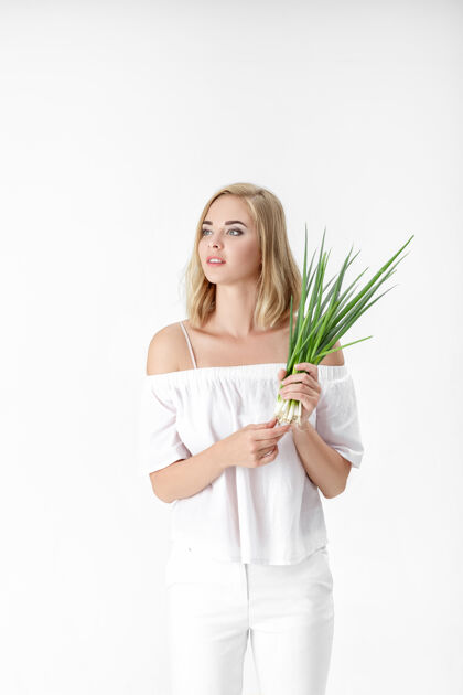 蔬菜一个穿着白衬衫的金发美女 手里拿着一个洋葱背景.健康还有维生素微笑素食者健康