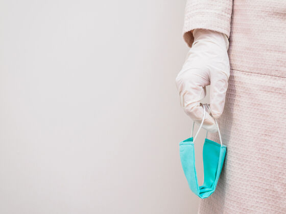 肺炎一只手戴着橡胶手套 手里拿着一个无菌的绿色防护医用口罩 复印空间职业闪光灯手套