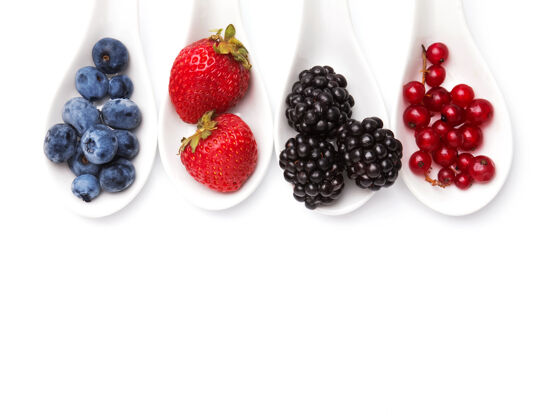 草莓汤匙上的夏天浆果是白色背景的健康有机吃