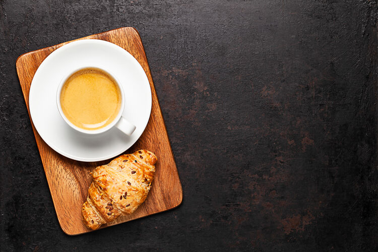 新鲜一杯咖啡和羊角面包放在木板上放在古老的乡村背景上食物顶部木板