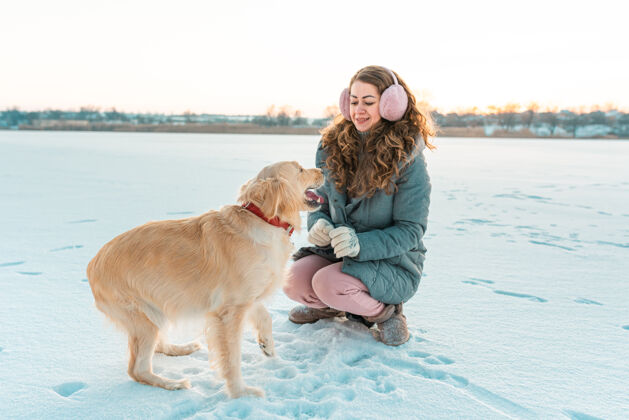 宠物大金毛猎犬给它的主人一只爪子冬天的白色风景天气肖像国内