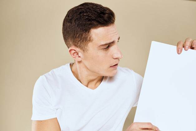 男性穿白色t恤的人手里拿着一张纸复印空间裁剪成米黄色公司信息沟通