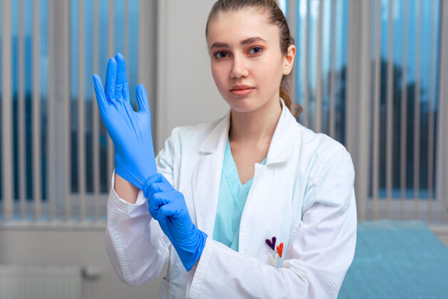 外科医生医生的手戴上乳胶手套在医院里 一个女人穿着医生的工作服 戴着乳胶手套防止病毒和细菌危害健康外科手术乳胶医生
