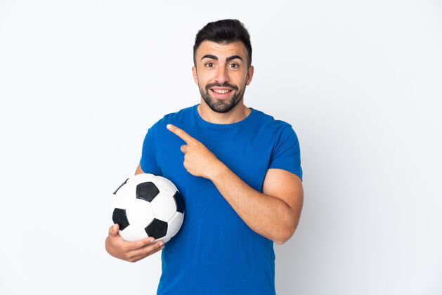 球员帅气的年轻足球运动员男子隔着隔离墙指着旁边的产品介绍表情手势表情