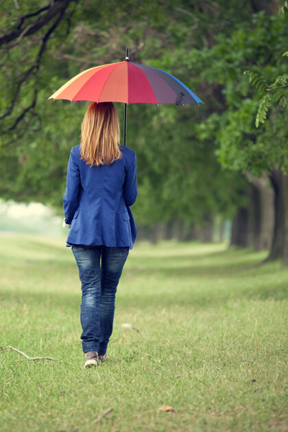 羽绒春天户外 年轻的时尚女孩带着雨伞青少年看高
