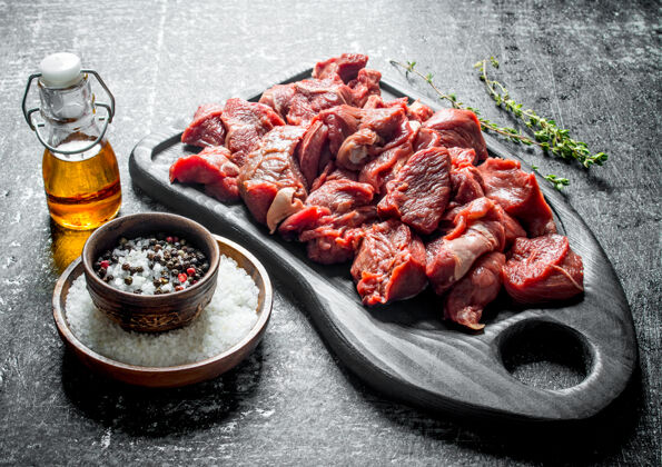 餐在切肉板上切生牛肉 用调味料和油装在瓶子里新鲜红色生的