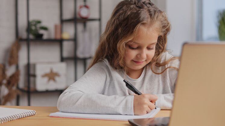 学习可爱的小学生在家用笔记本电脑学习计算机距离学习 家庭教育学校远程教育笔记本电脑
