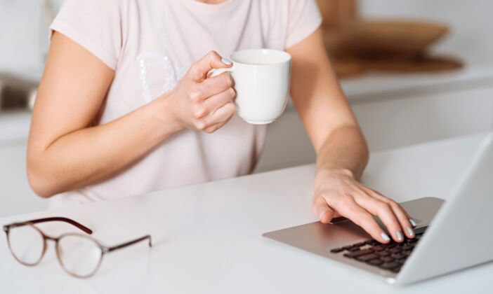 电子邮件有一些计划精致聪明优雅的女人一边吃早餐 一边坐在阳光明媚的厨房里 一边用电脑寻找所需的食材电脑教育日常