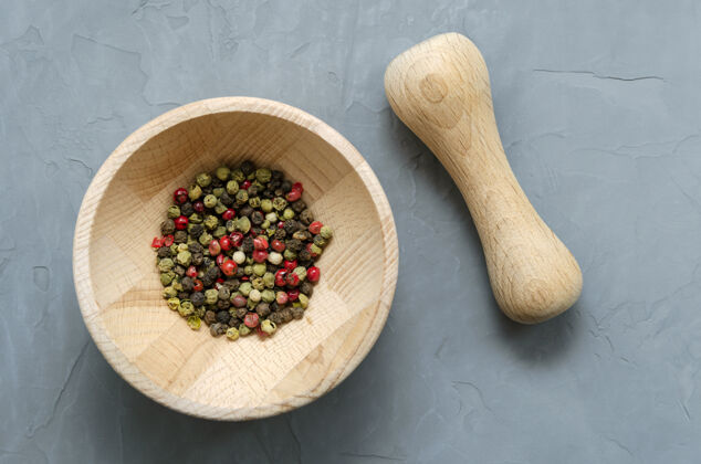 蔬菜多色红绿色黑胡椒粉在木臼里食物碗香料