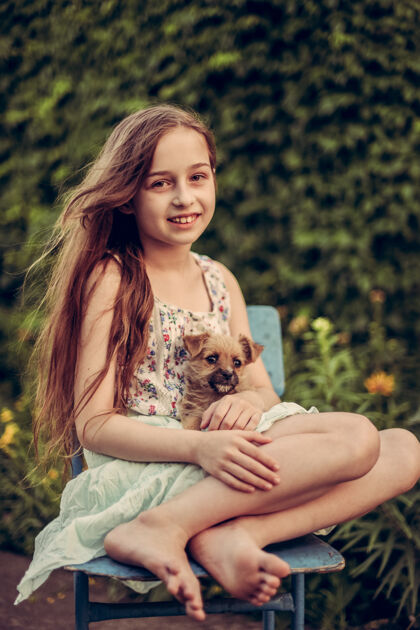动物一个金发小女孩带着她的宠物狗在外面停车场女孩喜欢一只小狗家庭狗女孩