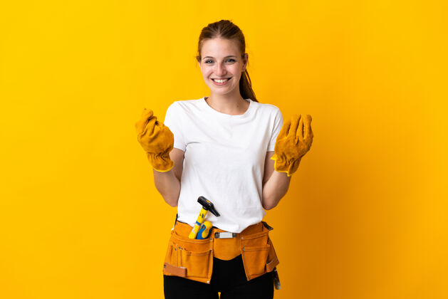 修理年轻的电工女人孤立在黄色背景下赚钱的手势成人女人年轻