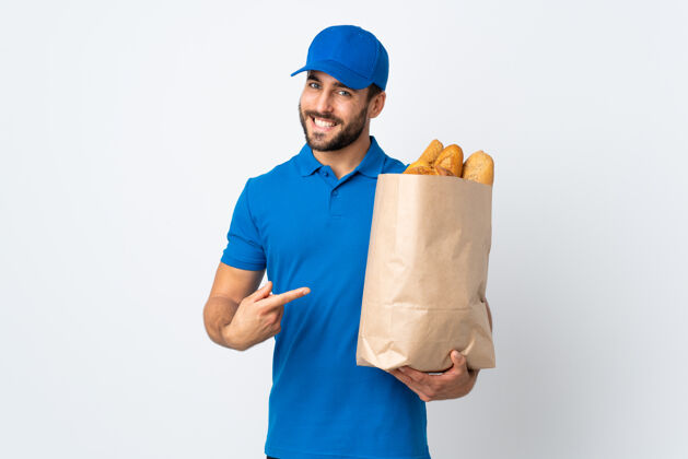 烤箱送货员拿着装满面包的袋子 指着白色的面包年轻信心方向