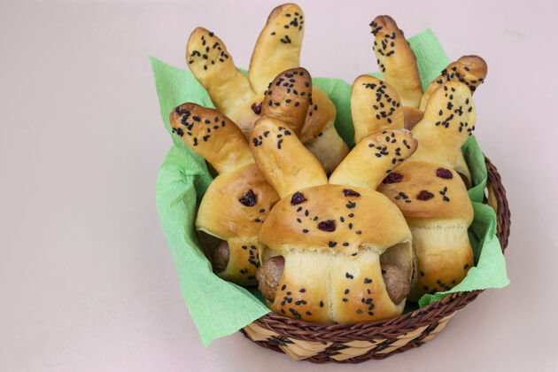 季节复活节兔子面包放在一个灯芯篮子里 为孩子们准备了一个美食 特写孩子发髻自制