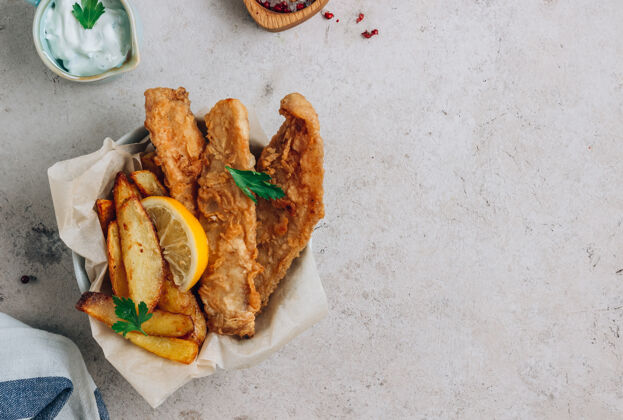 薯条传统的英国炸鱼和薯条 在轻质混凝土上加上鞑靼沙司背景.top查看鱼法国晚餐