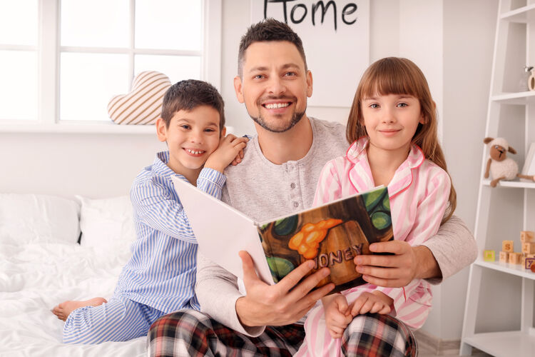 护理爸爸和他的小孩在家里读睡前故事男人时间肖像