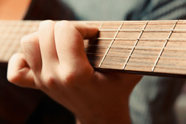 流行一个超级特写一只手触摸西班牙吉他 概念拍摄音乐剧男性沙发歌曲