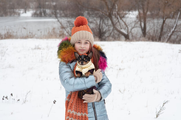 下雪了冬日少女的画像在她的温暖服装.青少年雪地里戴帽子的女孩天气.雪!雪 女人 衣服 帽子 少年 天气 寒冷 女人 季节 美丽 下雪
