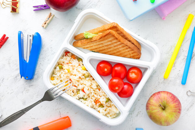 营养桌上摆着美味的食物和文具的学校午餐盒午餐时间健康书房