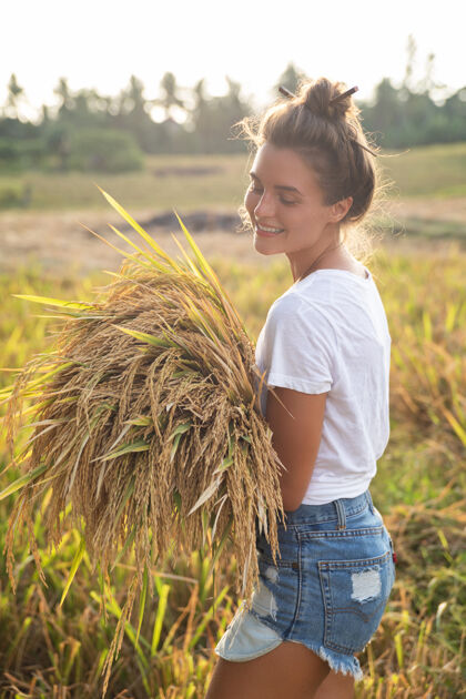 体验生态旅游还是日常生活工作快乐女农场主在稻田收割农场女人旅行