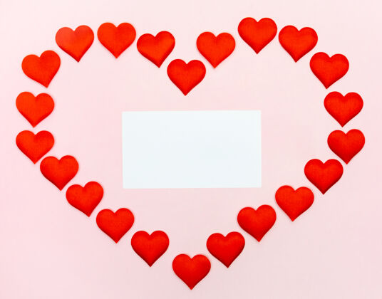 边界大心形的小心形里面有一张纸 模型上是粉红色的墙.概念节日和情人节的节日情人节笔记庆祝