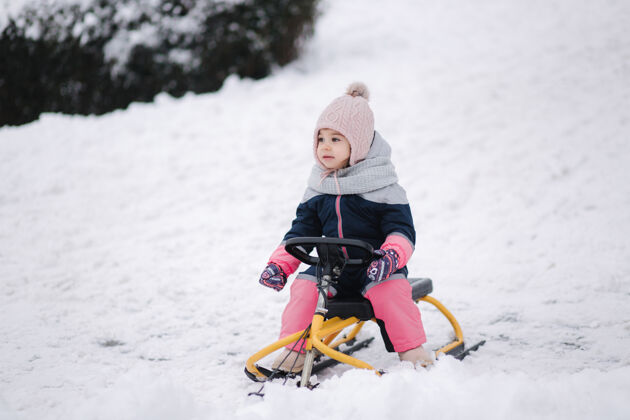 孩子小女孩喜欢坐雪橇骑年轻微笑