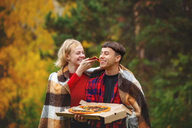 饮食一对年轻有趣美丽的男女一起享受披萨和社交野餐放松健康玩耍