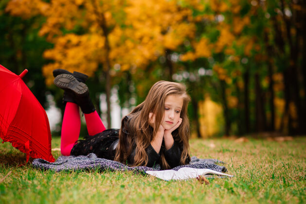公园秋林伞下年轻迷人的微笑女孩森林天气快乐
