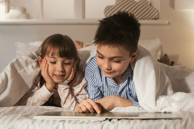 舒适小孩子在家里读睡前故事可爱卧室床