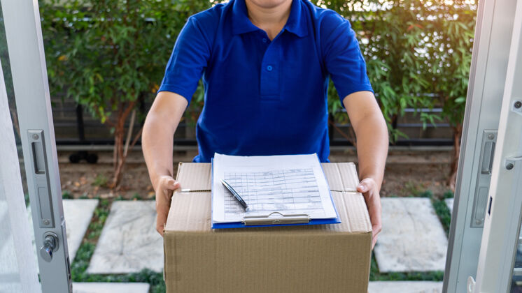 邮政快递员检查或拿着纸板包裹快递给客户服务男人接收