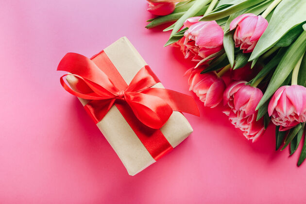 礼物礼盒和一束美丽的郁金香在粉红色蝴蝶结郁金香花