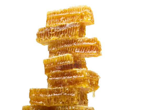 花蜜从蜡金字塔上滴下的几滴新鲜蜂蜜蜂蜜 维生素营养和蜂产品美味食物甜点