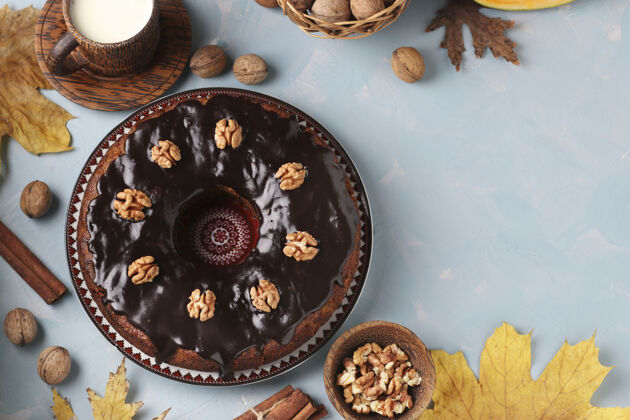 糕点自制南瓜松饼装饰着巧克力糖衣和核桃在浅蓝色零食健康新鲜